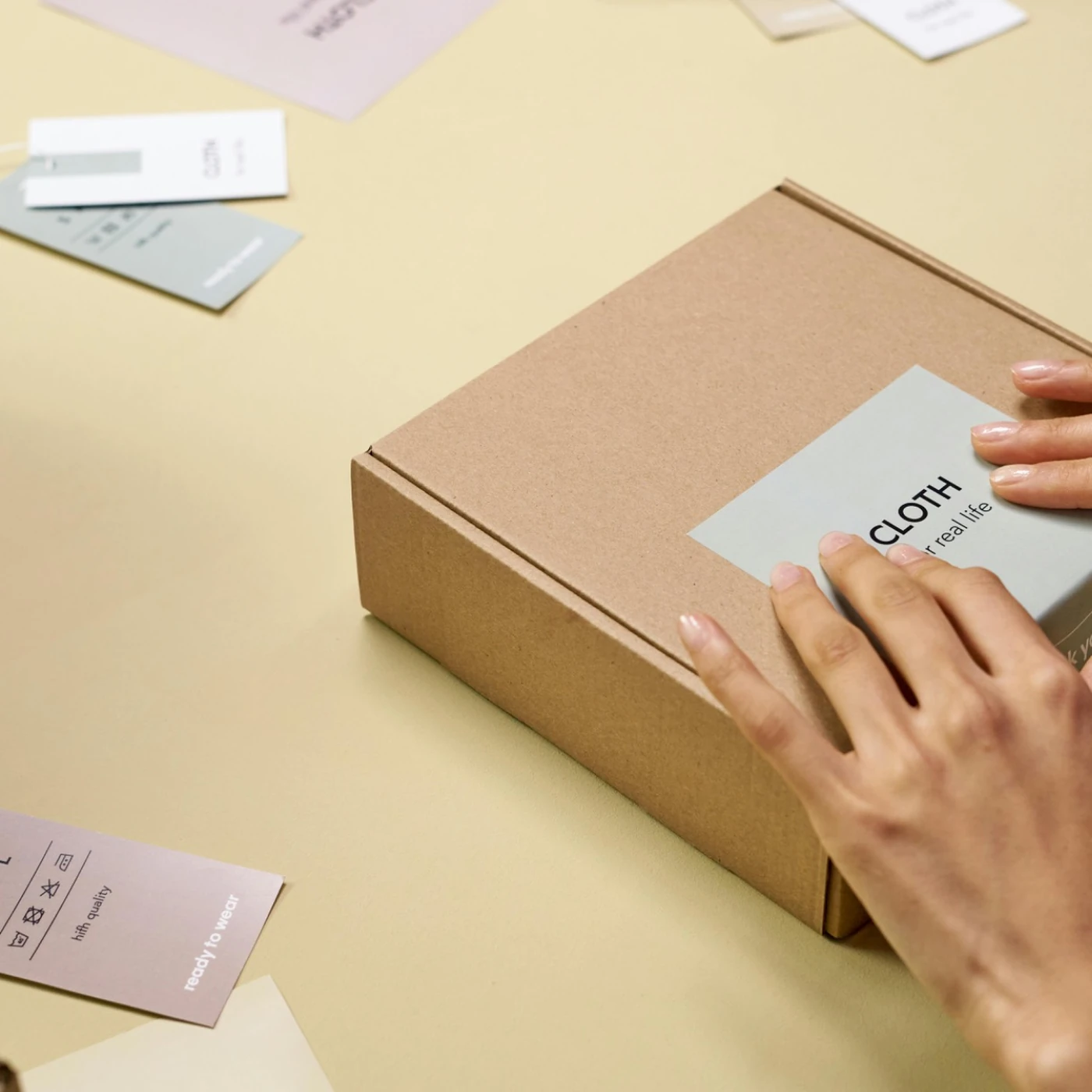 Hands applying a label to a kraft cardboard box
